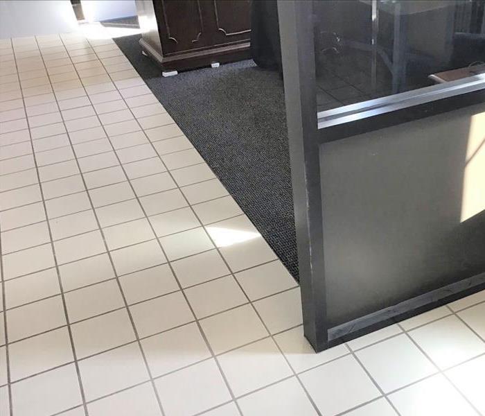 Dry white tile and grey/blue carpet in office building